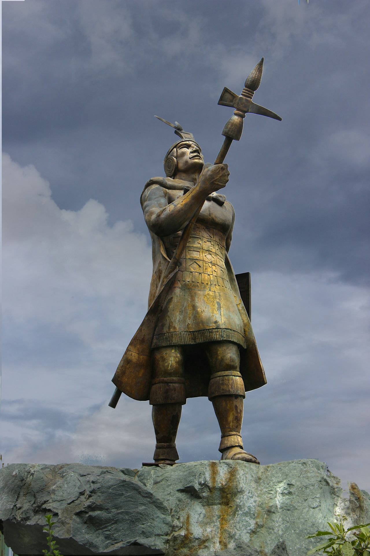 a statue of a man holding a bird on top of a rock