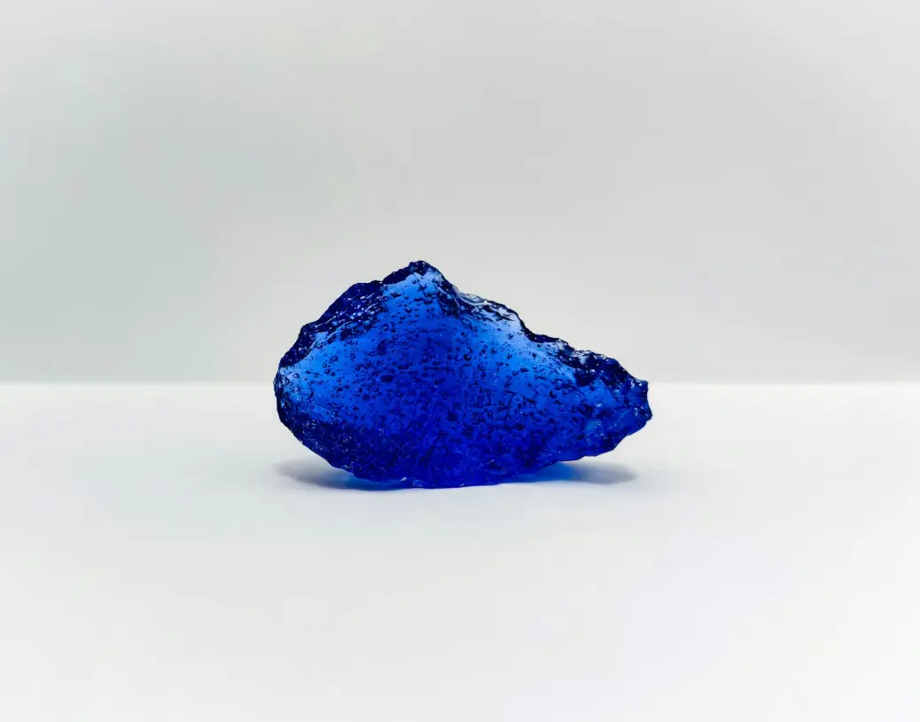 a blue rock on a white surface