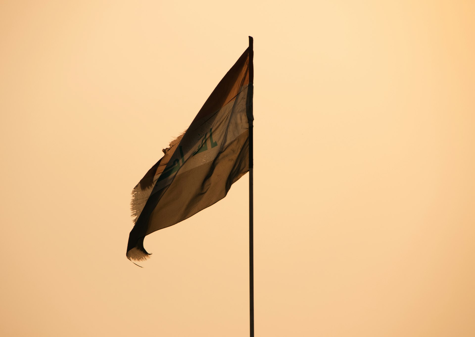 A flag flying in the wind on a pole