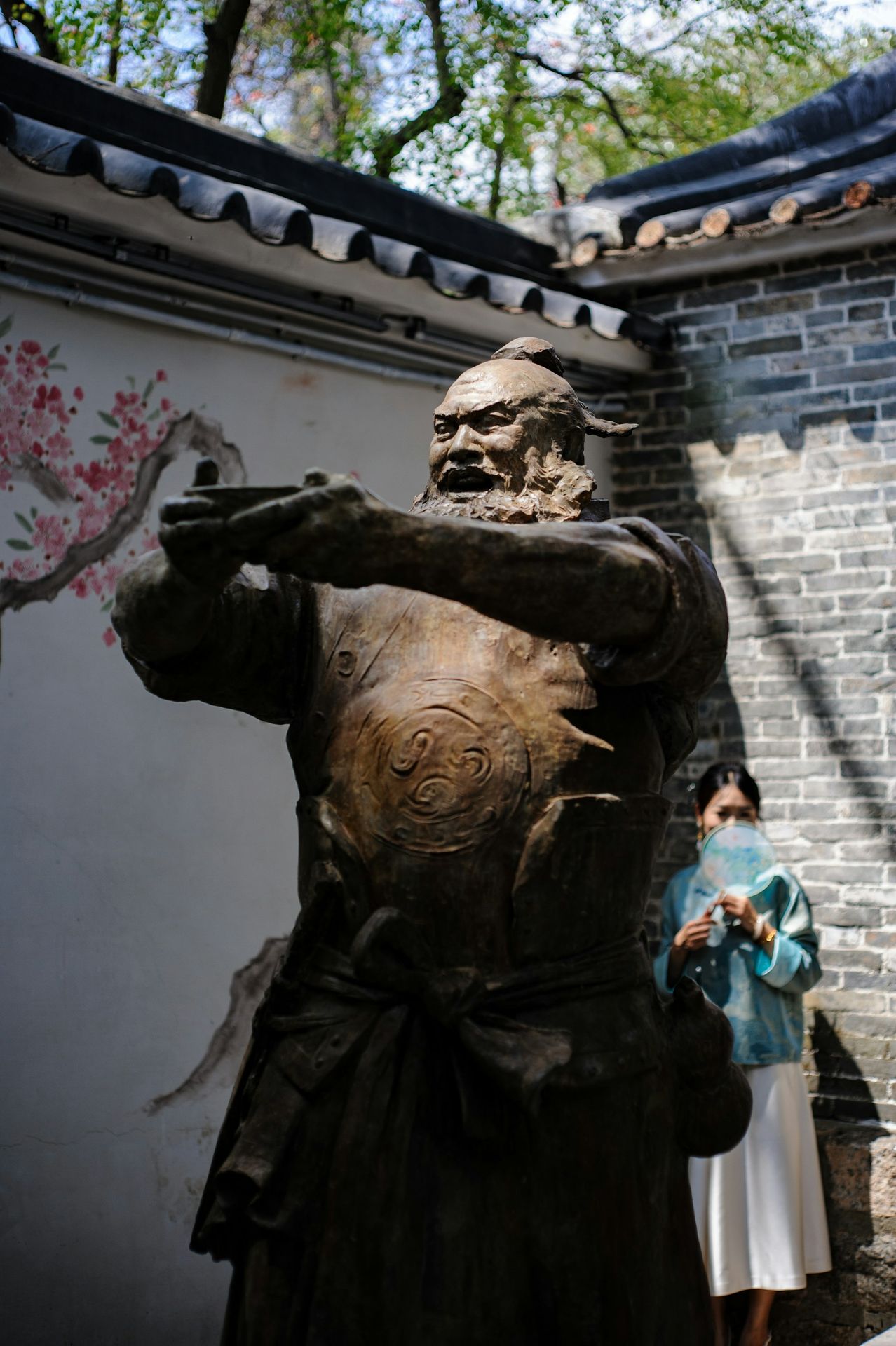 a woman standing next to a statue of a man