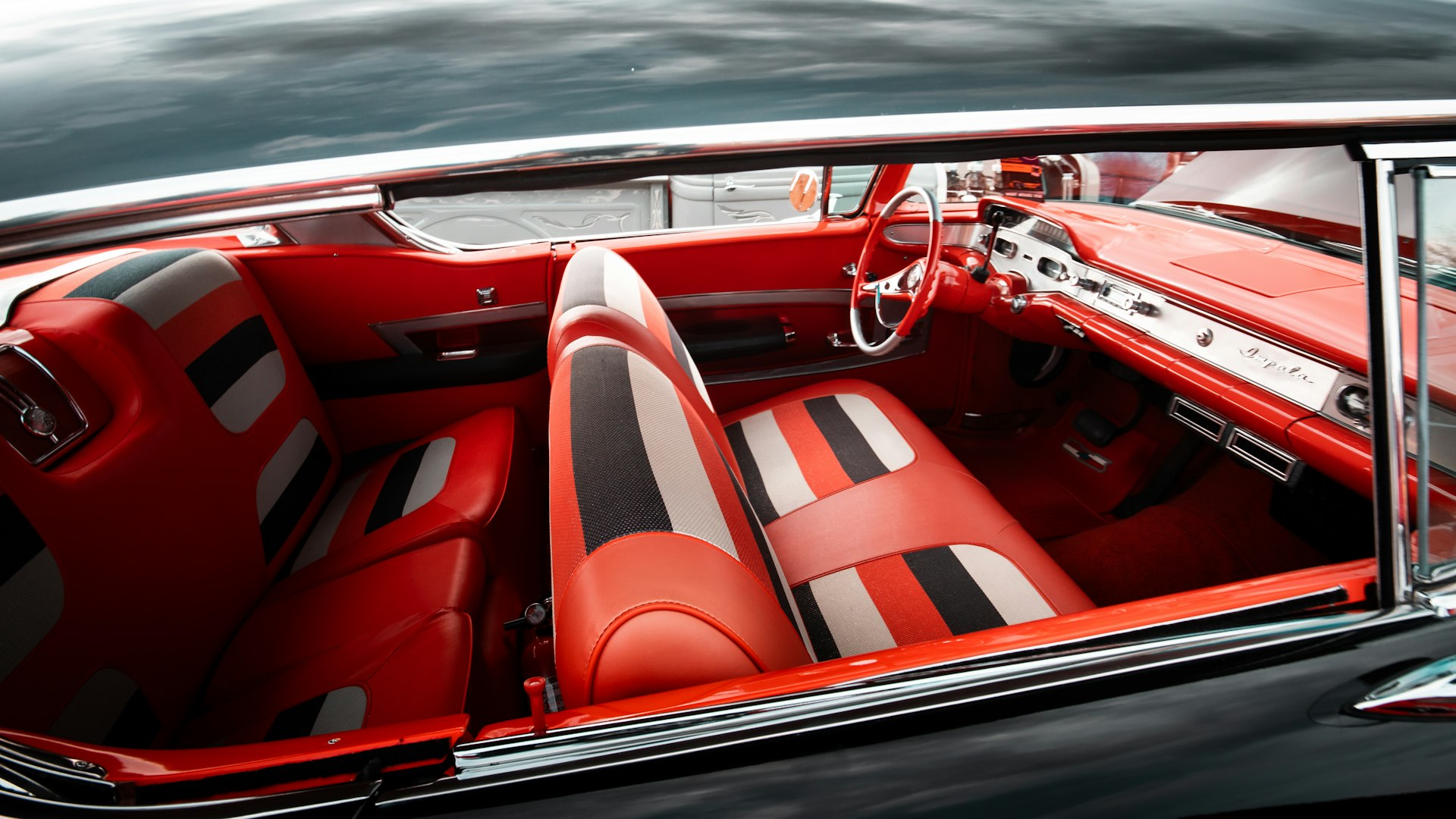 the interior of a classic car with red leather seats