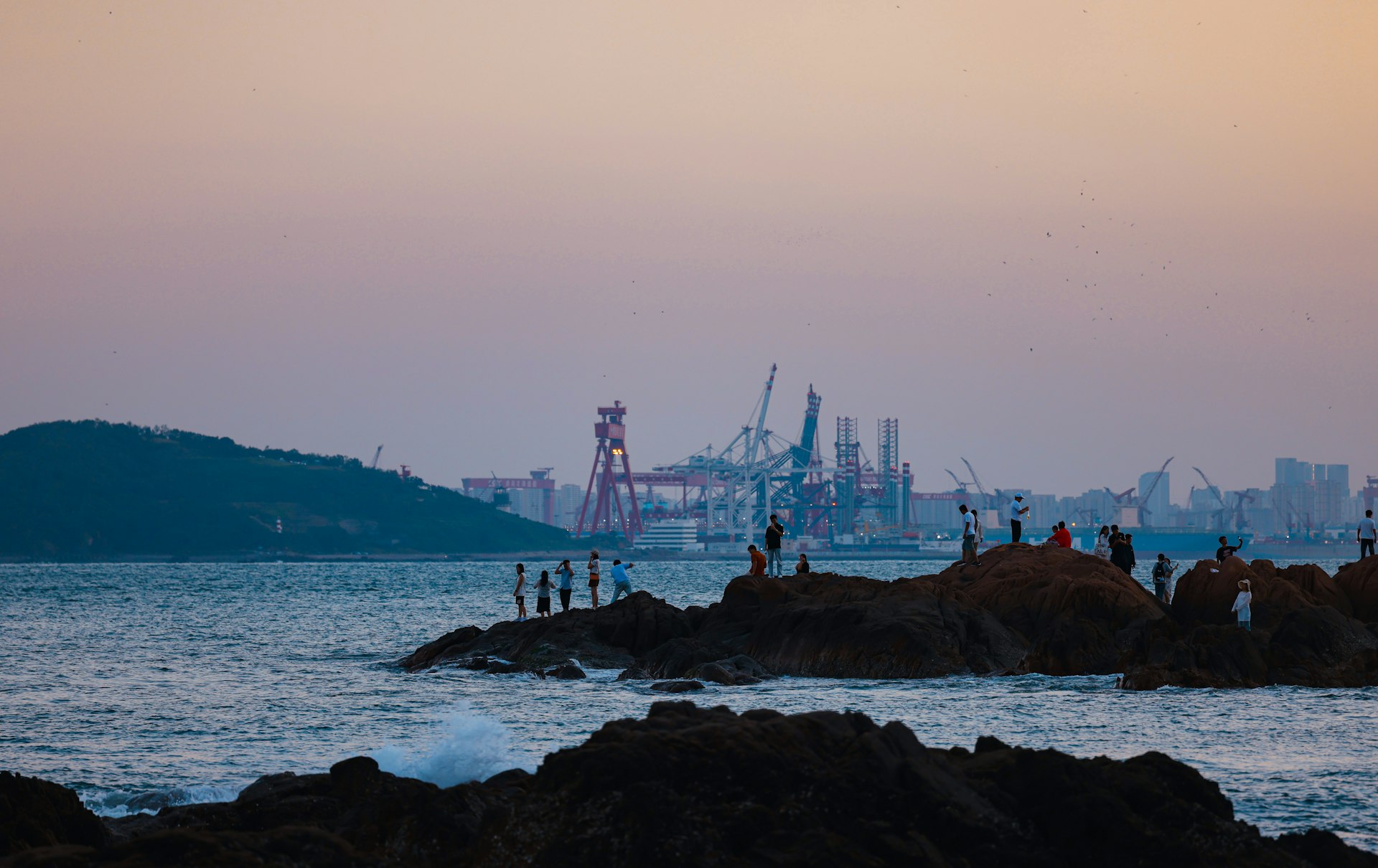 A group of people standing on top of a rocky beach
